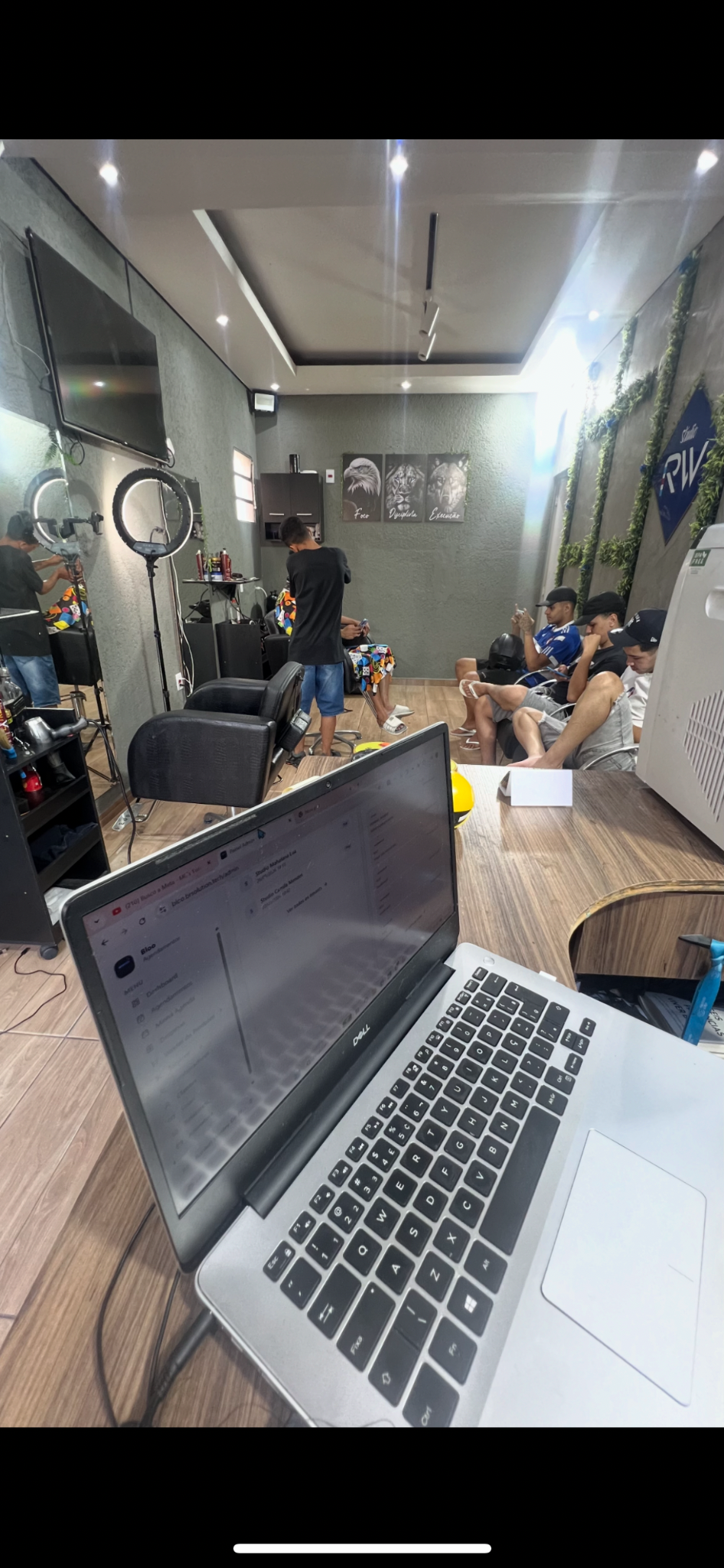 Barbearia RW em funcionamento com clientes no ambiente